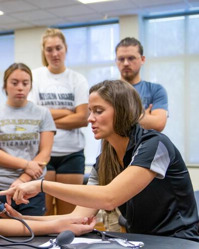 Samantha Wilson instructing students on bandaging