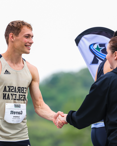 Garret Lenners receives award after a track and field event. 