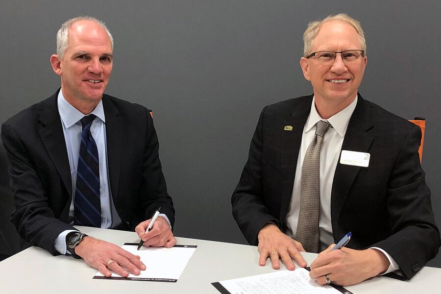 NWU President Darrin Good sitting next to SCC President Paul Illich signing paperwork.