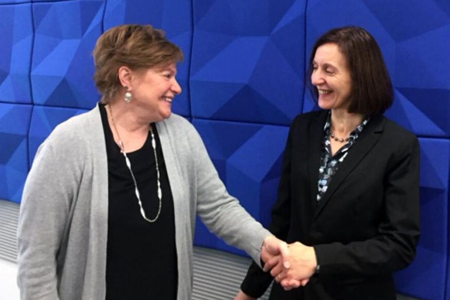 NWU Provost Graciella LivCaneiro-Livingston shakes the hand of Sue Raftery, associate vice president of academic affairs at Metropolitan Community College