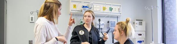 Nursing students with Professor Brittney Fritzinger in a nursing lab.