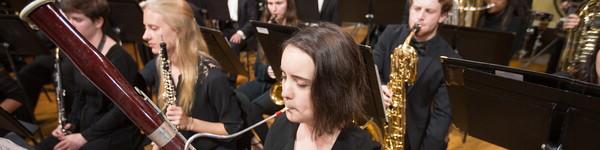 Orchestra students playing their instruments during a music concert.