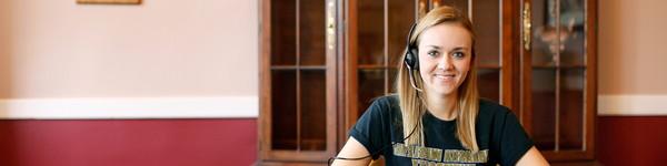 A femail NWU student wearing a headset.