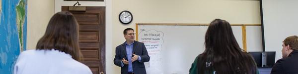 Professor Baumann delivers a lecture at the front of a classroom.