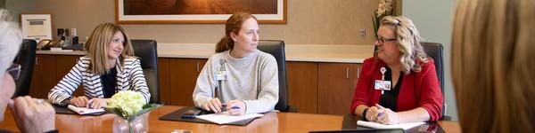 Nurse administrators with an MSN degree sitting in a conference room.