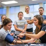 Samantha Wilson instructing students on bandaging